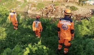 Miembros de la Defensa Civil buscan al menor de edad.