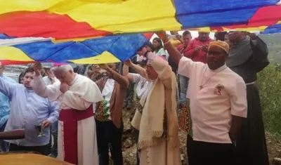 Los arzobispos, de Cali, monseñor Darío de Jesús Monsalve, y de Popayán, monseñor Luis José Rueda Aparicio, mientras hacen una oración junto a un carro incinerado, este domingo en Tacueyó, Cauca