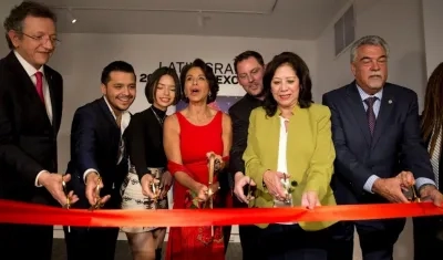 Miembros de la junta cortando el listón que inaugura la exposición.