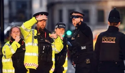 Agentes de policía cercan el lugar en el que se ha perpetrado, este viernes, un ataque terrorista, en Londres (Reino Unido). 
