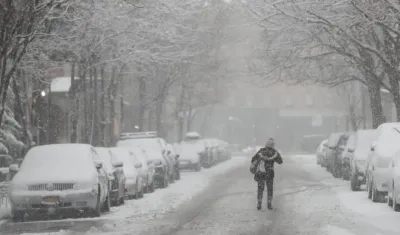 Una mujer camina por la carretera durante la tormenta de nieve en Nueva York
