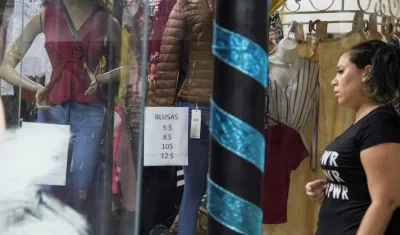 Una mujer mira los precios en dólar en una tienda.