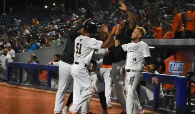 Peloteros de Gigantes celebran tras montarse en el marcador.
