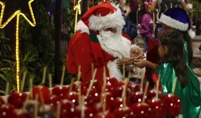 Hombre vestido como Papá Noel compartiendo con los niños.