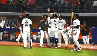 José Rosario festeja una anotación con sus compañeros de los Gigantes.