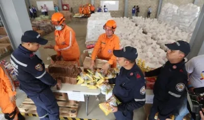 Autoridades organizan este viernes el cargamento con la ayuda humanitaria para Venezuela en un centro de acopio.