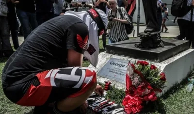 Un hombre pone flores en homenaje a las víctimas del incendio registrado en la madrugada de este viernes, en el centro de entrenamiento del club de fútbol Flamengo.