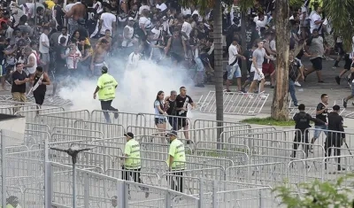 Aficionados corren despavoridos en medio de los disturbios.