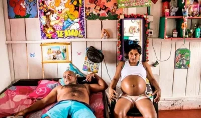 Yorladis, sentada en su habitación con la camiseta medio levantada.