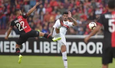 Joel Sánchez (i) de Melgar disputa el balón con Román Martínez (c) de San Lorenzo.