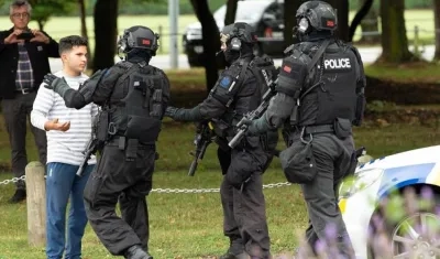 Policías hacen retroceder a personas de la escena de un tiroteo que resultó en múltiples muertes y lesiones, este viernes en Masjid Al Noor en Deans Avenue, en Christchurch (Nueva Zelanda). 