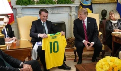 El presidente de Estados Unidos, Donald Trump (2d), recibe una camiseta de la selección brasileña de fútbol durante una reunión mantenida con su homólogo brasileño, Jair Bolsonaro (2i), en la Casa Blanca.