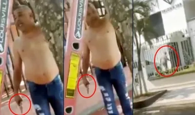 El usuario, con revólver en mano, amenazando a la cuadrilla y luego ingresando al establecimiento comercial.