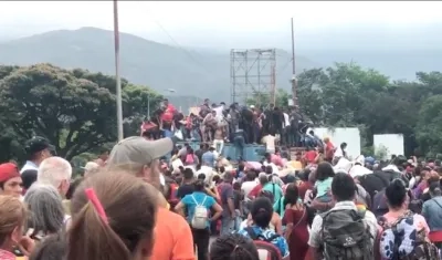 Numerosas personas superando los contenedores dispuestos por el gobierno venezolano en la frontera.