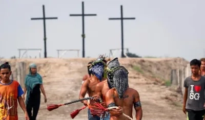 Penitentes con máscaras participan en el Viernes Santo en la aldea de San Juan, San Fernando, Pampanga, Filipinas.