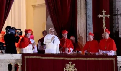 El cardenal argentino Jorge Mario Bergoglio (c) saluda desde el balcón tras ser elegido Papa en la plaza de San Pedro de la ciudad del Vaticano el 13 de marzo de 2013.