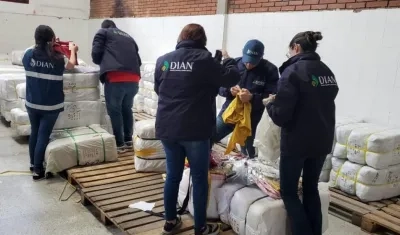 Personal de la Dian contabilizando las prendas de contrabando incautadas.