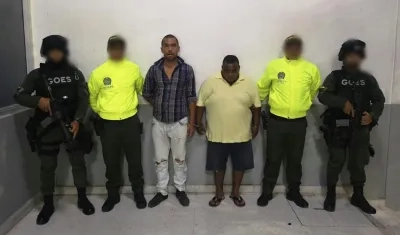 Los dos hombres capturados con miembros de las instituciones que participaron en el operativo.