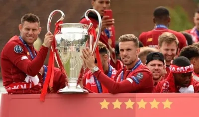 Jugadores del Liverpool celebran con el trofeo de la Liga de Campeones. 