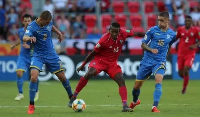 El panameño Axel McKenzie (c) disputa el balón con los ucranianos Valerii Bondar (i) y Kyrylo Dryshliuk (d)