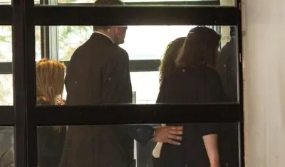 La cantante Shakira (al fondo, tapada) ha eludido este jueves a la prensa que la esperaba a las puertas del juzgado de Esplugues.