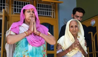 La mujer (i) y la madre de dos de los acusados de violar y asesinar a una niña de ocho años rezan antes del veredicto final, este lunes en Kathua (India). 