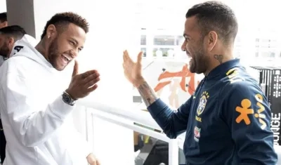 Neymar se saluda con Dani Alves. 