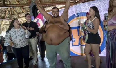 Rolando Javier Mena Salablanca (c), de 44 años, celebra luego de ganar el concurso "Papá Panzón" este viernes en Managua (Nicaragua). 