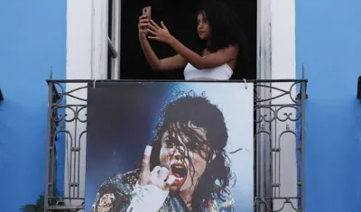 Una joven se hace una foto en un balcón, donde se grabo el video del cantante 