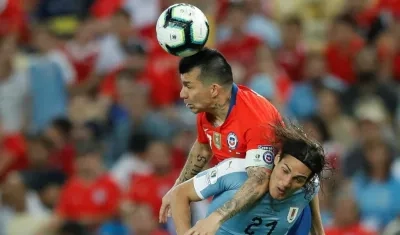 Gary Medel disputa la pelota con Edison Cavani. 