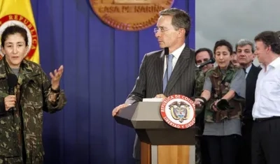 Íngrid Betancur el día de la liberación, con Uribe y Santos.