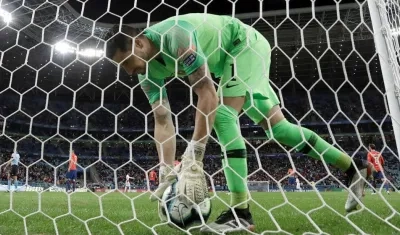 El arquero de Chile Gabriel Arias recoge el balón después de recibir un gol durante el partido Chile-Perú.