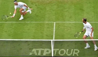 Robert Farah ataca la bola ante la mirada de Juan Sebastián Cabal.