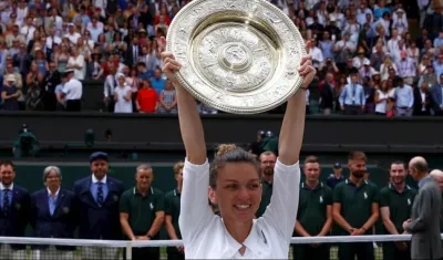 Simona Halep levanta el trofeo de ganadora del Abierto de Wimbledon. 