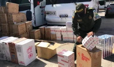 Un policía inspecciona el bus cargado de mercancía de contrabando.