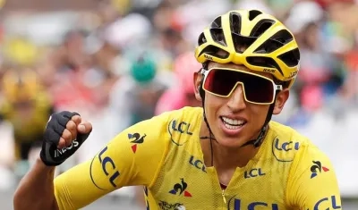 Egan Bernal levanta su brazo derecho en señal de triunfo.