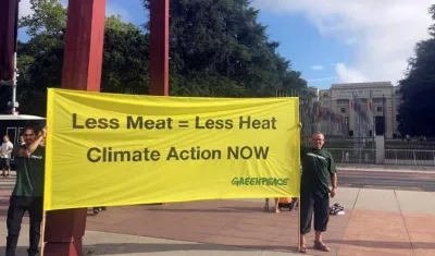 Dos miembros de Greenpeace muestran una pancarta con el mensaje 'Menos carne es igual a menos calor. Acción climática ahora'.