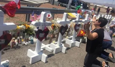 Una señora ora junto a las cruces que fueron colocadas frente a la tienda Walmart en El Paso, Texas, lugar donde ocurrió una masacre.