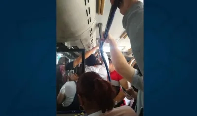 Un bus de Transmetro repleto de pasajeros y sin aire acondicionado.