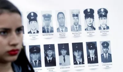 Asistentes observan fotografías durante la conmemoración del Día Internacional de las Víctimas de Desapariciones Forzadas, este viernes en Bogotá.