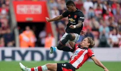 Marcus Rashford es barrido por un defensor. 