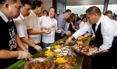 Funcionarios y comerciantes comieron platos de carne de cerdo para demostrar que la carne que se vende localmente es segura.