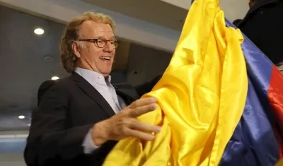 El violinista de Países Bajos André Rieu enarbola este lunes una bandera colombiana tras arribar al Aeropuerto Internacional El Dorado, en Bogotá (Colombia).