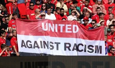 Aficionados muestran una pancarta rechazando el racismo. 