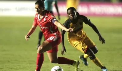 Catalina Usme, del América, disputando e balón con Yisela Cuesta, del DIM.