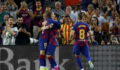Antoine Griezmann se abraza con Lionel Messi y Arthur Melo los observa. 