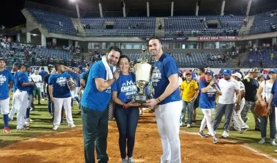 Ozzie Guillén celebra el título de campeón, mientras su esposa Ibis Cárdenas y su hijo Ozney Guillén levantan el trofeo. 