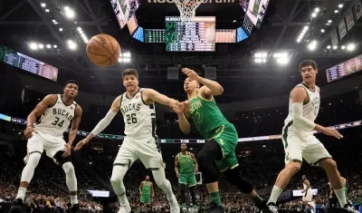 Jugadores de los Bucks observan a la pelota salir por la línea de fondo. 