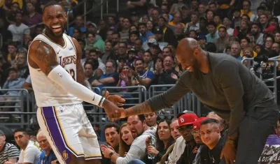 LeBron James le da la mano a Kobe Bryant durante un partido de los Lakers. 