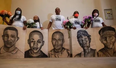 Familiares de las víctimas de la masacre de Llano Verde, sostienen hoy retratos suyos durante un acto conmemorativo, en Cali (Colombia). 